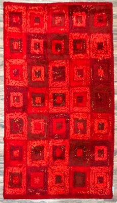 un tapis rouge avec des carrés et encore des carrés dessus
