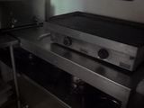 stainless steel counter top in a restaurant kitchen with a sign on the wall behind it