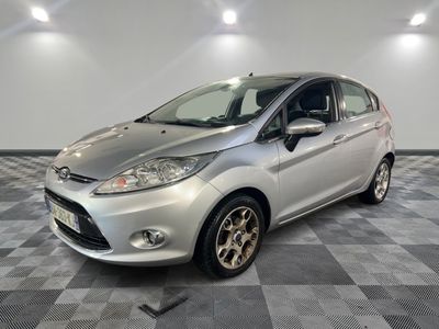 une Ford Fiesta argentée garée sur un sol en carrelage à damier