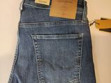 the back of a pair of jeans with a pair of scissors next to it
