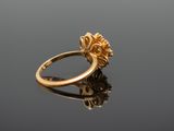 a close up of a gold ring on a reflective surface