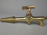 an old brass faucet with a brass handle on a gray background
