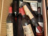 plusieurs bouteilles de vin dans un carton posé sur le sol
