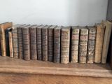 many books on a shelf next to a guitar amp