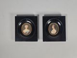 deux portraits miniatures représentant une femme et un homme, sur des socles noirs