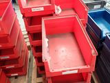 a lot of red bins sitting on a pallet in a warehouse