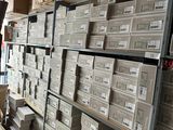 boxes are stacked on a shelf in a warehouse with a man looking at them