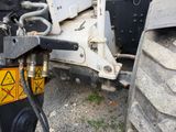 a close up of a tractor with a hose attached to the back of it