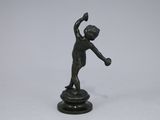 bronze figurine of a boy holding a tennis racquet
