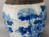 a blue and white vase with flowers on it
