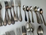 a lot of spoons and forks laid out on the table