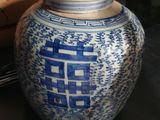 un vase bleu et blanc posé sur une table, avec une boîte en arrière-plan