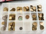 a lot of coins in a plastic box on a table