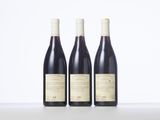 three bottles of wine sitting on top of a white table