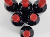 six bottles of wine are arranged in a circle on a white surface