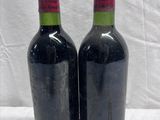 two bottles of wine sitting on top of a white table