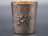 a close up of a silver cup with flowers on it