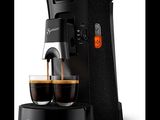 une cafetière noire avec deux tasses de café à côté
