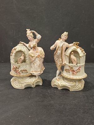 pair of porcelain figurines of a woman and a man on a carriage