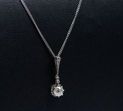 un collier en or blanc orné d'un pendentif en diamant, monté sur un cordon en cuir noir