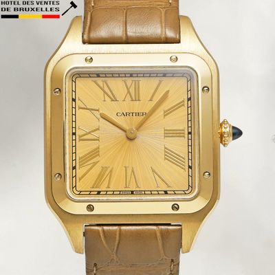 a close up of a gold watch with roman numerals on the face