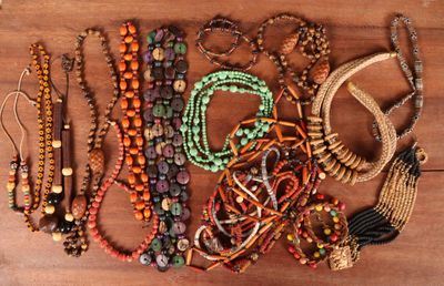 de nombreuses perles et bracelets de différentes couleurs disposés sur une table