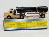 a toy truck with a large load of pipes on top of it