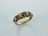 a close up of a gold ring with purple stones on it