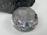 a glass ball sitting next to a rock on a table