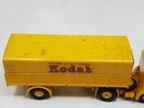 yellow toy truck with a yellow trailer on a white surface