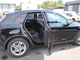 a black car with its door open in a parking lot
