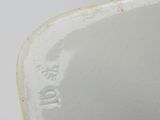 underside view of a white porcelain vase with a bird on it