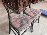 pair of antique chairs with upholstered seats in a store