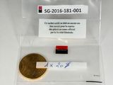 une pièce d'or et un petit bout de papier posés sur une table
