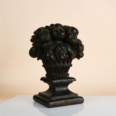 a vase with a bunch of grapes on it on a table
