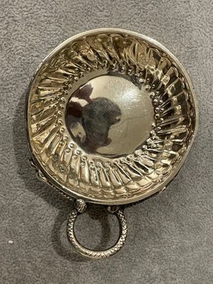 une assiette en argent dans laquelle se reflète une personne