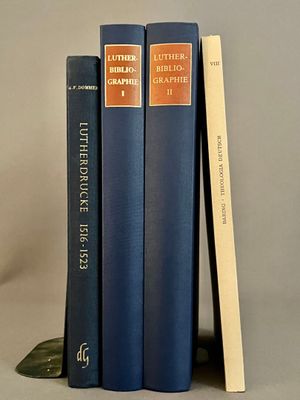 trois livres sont empilés sur une table