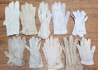plusieurs paires de gants blancs posées sur une table en bois