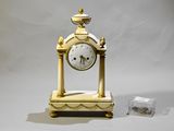a gold clock sitting on top of a white table