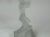 statue d'une femme tenant un vase, posée sur un socle, sur une surface blanche