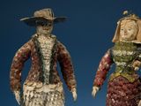 two figurines of a man and a woman dressed in period clothing