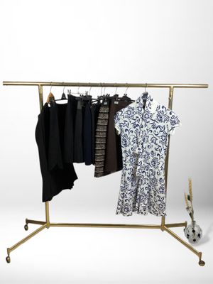 a clothes rack with clothes hanging on it and a guitar