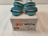 une boîte sur laquelle est posée une paire de chaussures bleues