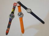 trois montres différentes posées les unes à côté des autres sur une table blanche