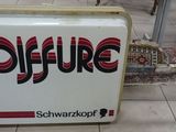 a sign that says coffure on it in the middle of a tiled floor