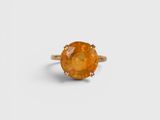 an orange sapphire ring on a white background