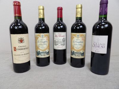 quatre bouteilles de vin sont alignées sur une table