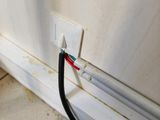 a black wire that is connected to a white wall