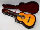 a guitar in a case sitting on a white surface
