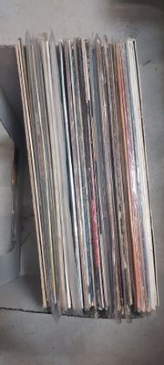 beaucoup de disques dans une boîte posée par terre